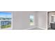 Bedroom with two windows and a view of the outside community, next to a bathroom with light gray cabinets at 23 Marden Dr # 51, Ormond Beach, FL 32176