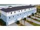Exterior of newly constructed three-story townhomes in light blue and white with dark roofs and attached garages at 23 Marden Dr # 51, Ormond Beach, FL 32176