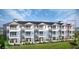 Beautiful exterior elevation showing multiple units with blue accents, white trim, and manicured landscaping at 23 Marden Dr # 51, Ormond Beach, FL 32176