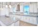 Modern kitchen boasts white cabinetry, granite countertops, mosaic backsplash, and stainless steel range hood at 23 Marden Dr # 51, Ormond Beach, FL 32176