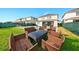 Spacious backyard featuring a patio with outdoor seating, lush grass, and a view of the neighboring houses at 7682 Fairfax Dr, Kissimmee, FL 34747