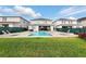 Expansive backyard with a sparkling pool, spa, lush green grass, and lounge seating at 7682 Fairfax Dr, Kissimmee, FL 34747