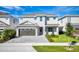 Beautiful two-story home with a paved driveway, stone accents, manicured lawn, and attached two car garage at 7682 Fairfax Dr, Kissimmee, FL 34747