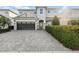 Charming two-story home featuring a paved driveway, a two-car garage, and lush landscaping at 7682 Fairfax Dr, Kissimmee, FL 34747