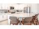 Bright kitchen featuring white cabinets, stainless steel appliances, a breakfast bar with seating and tile floors at 7682 Fairfax Dr, Kissimmee, FL 34747