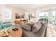 Inviting living room with a comfortable oversized sofa, TV, and sliding glass doors leading to the outdoor pool at 7682 Fairfax Dr, Kissimmee, FL 34747