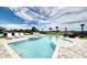 Relaxing backyard oasis with a sparkling pool, spa, lounge chairs, and lush landscaping at 7682 Fairfax Dr, Kissimmee, FL 34747