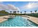 The inground pool with attached spa is surrounded by lounge chairs and decorative palms at 7682 Fairfax Dr, Kissimmee, FL 34747