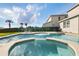 Relaxing backyard pool and spa with patio seating and lush tropical landscaping at 7682 Fairfax Dr, Kissimmee, FL 34747