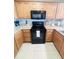 Well-equipped kitchen with wooden cabinetry, modern black appliances, and neutral-colored countertops at 13415 Blue Heron Beach Dr # 1006, Orlando, FL 32821