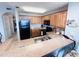Bright kitchen boasts wooden cabinets, black appliances, and granite countertops with a tiled floor at 13415 Blue Heron Beach Dr # 1006, Orlando, FL 32821