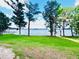 Grassy lawn and mature trees create a serene waterfront view for the property at 13415 Blue Heron Beach Dr # 1006, Orlando, FL 32821