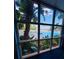 Bright pool view through large windows surrounded by lush tropical greenery at 13415 Blue Heron Beach Dr # 1006, Orlando, FL 32821