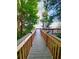 Picturesque wooden walkway surrounded by trees leads to a serene lake view at 13415 Blue Heron Beach Dr # 1006, Orlando, FL 32821