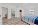 Open bedroom featuring a mirrored closet door, light wood flooring, and white trim at 211 Nw 8Th St, Mulberry, FL 33860