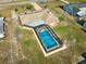 Aerial view of the house featuring a screened-in pool with a clean blue water at 6531 Red Grange Blvd, Indian Lake Estates, FL 33855