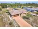 Aerial view of the home with a private driveway, mature trees, and well-maintained lawn at 6531 Red Grange Blvd, Indian Lake Estates, FL 33855
