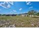 Expansive backyard with outbuildings and pool, set under a bright blue sky at 6531 Red Grange Blvd, Indian Lake Estates, FL 33855