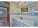 Well-lit bathroom with a decorative tile backsplash, vanity, and a glimpse of the shower at 6531 Red Grange Blvd, Indian Lake Estates, FL 33855