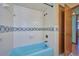 Clean and well-maintained bathroom with a blue bathtub-shower combo and decorative tile at 6531 Red Grange Blvd, Indian Lake Estates, FL 33855