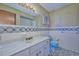 Well-lit bathroom with a decorative tile backsplash, vanity, and blue fixtures at 6531 Red Grange Blvd, Indian Lake Estates, FL 33855