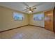 Cozy bedroom featuring tile flooring, ceiling fan, and a pair of windows for natural light at 6531 Red Grange Blvd, Indian Lake Estates, FL 33855
