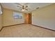 Comfortable bedroom features tile flooring, ceiling fan, and window letting in lots of natural light at 6531 Red Grange Blvd, Indian Lake Estates, FL 33855