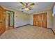 Spacious bedroom features tile flooring, ceiling fan, and a large closet for ample storage at 6531 Red Grange Blvd, Indian Lake Estates, FL 33855