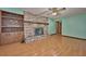 Cozy living room with a brick fireplace, built-in shelving, and hardwood floors at 6531 Red Grange Blvd, Indian Lake Estates, FL 33855