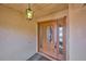 Close-up of the front door with glass panels and dark brown paint at 6531 Red Grange Blvd, Indian Lake Estates, FL 33855
