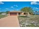Single-story home with a brown two car garage door, stone accents, and well manicured bushes at 6531 Red Grange Blvd, Indian Lake Estates, FL 33855