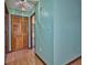 Hallway with wood floors, leading to the bathroom, and closet doors at 6531 Red Grange Blvd, Indian Lake Estates, FL 33855