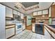 Well-lit kitchen with white appliances, tile floors, and a view of the dining area at 6531 Red Grange Blvd, Indian Lake Estates, FL 33855