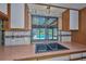 Kitchen sink with view of screened in pool area at 6531 Red Grange Blvd, Indian Lake Estates, FL 33855