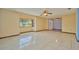 Bright living room with tile floors, a large window, and a ceiling fan for comfortable living at 6531 Red Grange Blvd, Indian Lake Estates, FL 33855