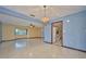 Open-concept living room with tile flooring, ceiling fan, and access to the kitchen area at 6531 Red Grange Blvd, Indian Lake Estates, FL 33855