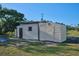 Several outbuildings with wooden exteriors are on a large grassy lot at 6531 Red Grange Blvd, Indian Lake Estates, FL 33855