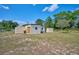 Spacious backyard with outbuildings including a garage and storage shed at 6531 Red Grange Blvd, Indian Lake Estates, FL 33855