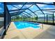 A screened pool with a ladder in a fenced yard at 6531 Red Grange Blvd, Indian Lake Estates, FL 33855