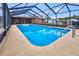 A bright blue screened in pool and patio area is ready for summer fun at 6531 Red Grange Blvd, Indian Lake Estates, FL 33855