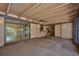 Spacious enclosed carpeted porch with exposed beam ceiling, offering ample space for relaxation and entertainment at 6531 Red Grange Blvd, Indian Lake Estates, FL 33855