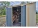 Open outdoor shed with log and tool storage on a grassy lot at 6531 Red Grange Blvd, Indian Lake Estates, FL 33855