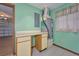 Functional utility room with tile floors, built-in desk/cabinet space, and easy access to the garage at 6531 Red Grange Blvd, Indian Lake Estates, FL 33855