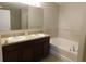 The primary bathroom features a dual sink vanity and soaking tub with tiled surround at 6954 Glenbrook Dr, Lakeland, FL 33811