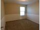 The carpeted bedroom has neutral walls, a window, and classic beadboard paneling at 6954 Glenbrook Dr, Lakeland, FL 33811