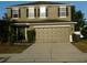 Two-story house with tan exterior, grey shutters, and a two car garage at 6954 Glenbrook Dr, Lakeland, FL 33811