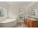 Bright bathroom featuring a soaking tub, double sink vanity, and natural light from a window at 7165 Cr 655, Bushnell, FL 33513