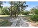 Long driveway leading to a charming property, framed by mature trees and lush greenery at 7165 Cr 655, Bushnell, FL 33513