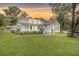 Charming two-story home with a welcoming front porch, well-maintained lawn, and a beautiful, colorful sunset at 7165 Cr 655, Bushnell, FL 33513