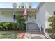Charming front porch with stairs, white railings, and an American flag at 7165 Cr 655, Bushnell, FL 33513